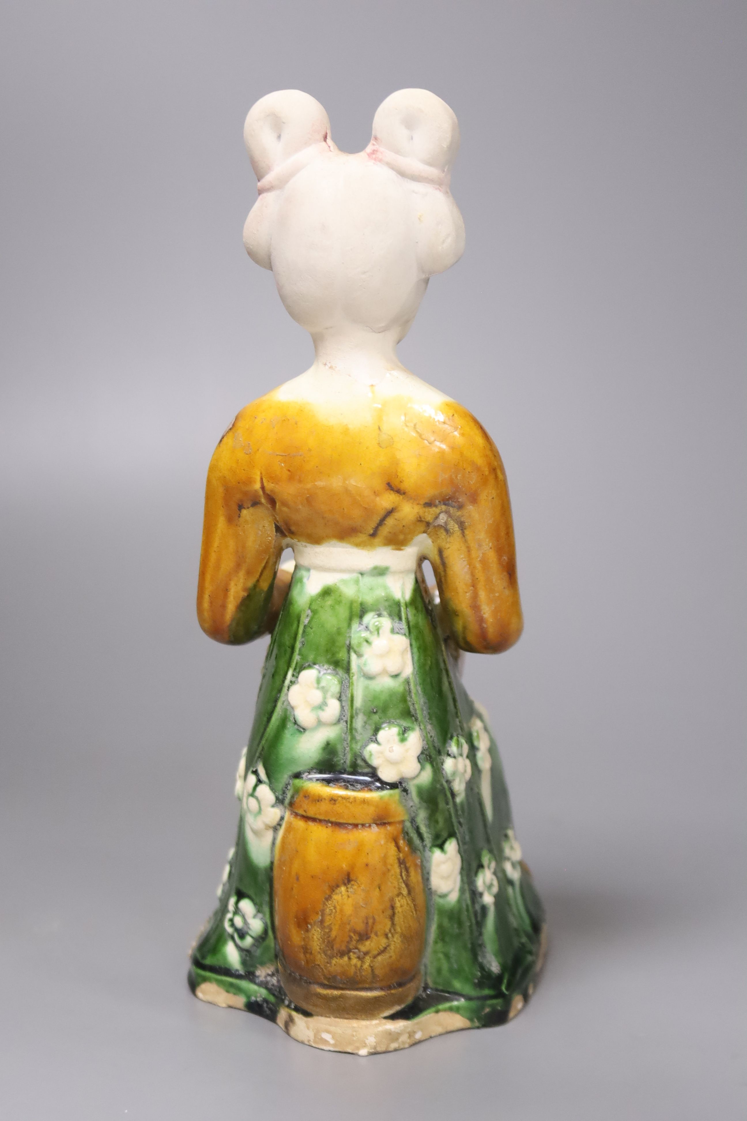 A large Chinese pottery figure of an aristocratic lady, wearing a floral skirt and seated, Tang dynasty style, 23cm high